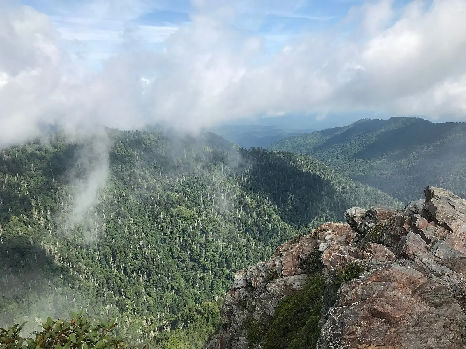 The rocky outcrop of Charlies Bunion on the Appalachian Trail in the Great Smoky Mountains, with cloud drifting over forested ridges behind